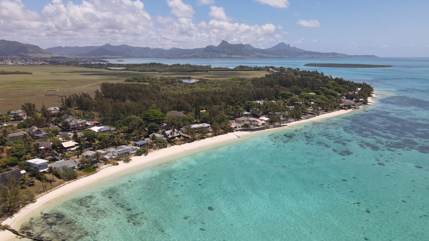 La longue plage de Pointe d'Esny vue du ciel, le lagon et les montagnes